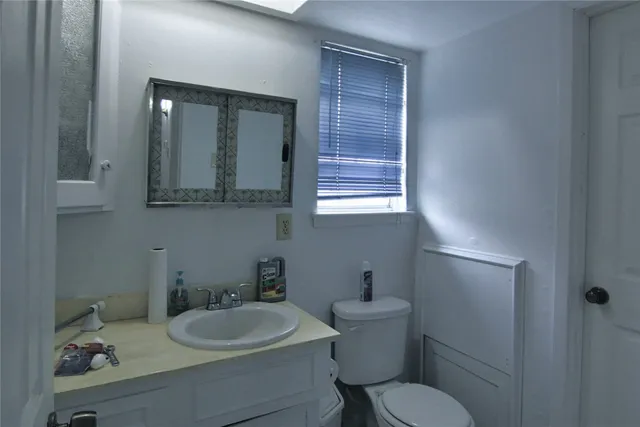 a bathroom with a toilet sink and mirror