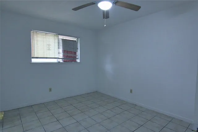 an empty room with a chandelier fan