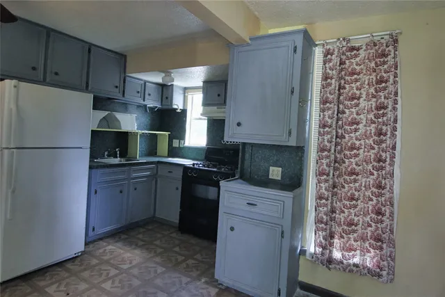 a kitchen with stainless steel appliances granite countertop a refrigerator and a stove
