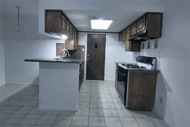 a kitchen with stainless steel appliances granite countertop a stove a sink and a refrigerator