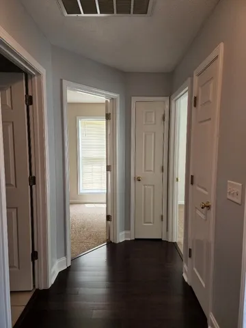 a view of a hallway with wooden floor