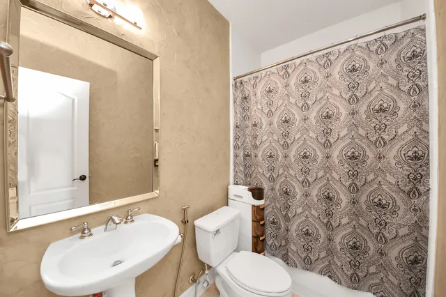 a bathroom with a toilet sink and mirror