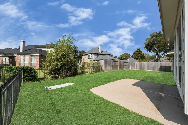 a view of a house with a big yard plants and large trees