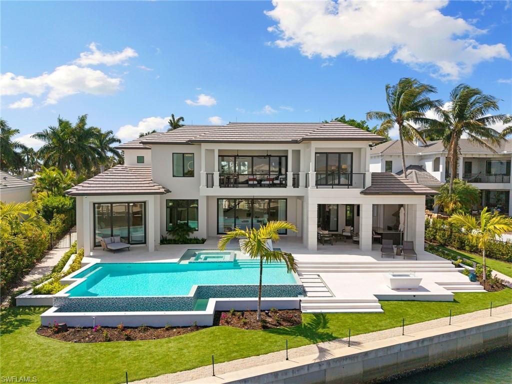2345 Tarpon Road Naples, FL 34102 - Photo 34 of 43 Rear view of house with a patio, an outdoor lounge area, a pool with connected hot tub, a balcony, and a tile roof