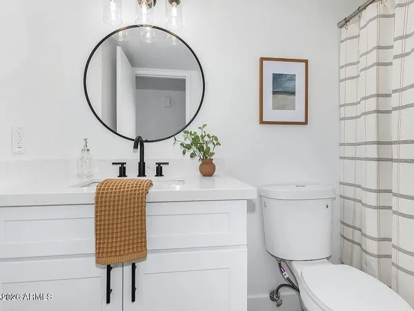 a bathroom with a sink toilet and a mirror