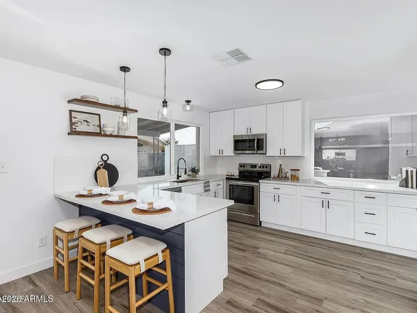 a kitchen with granite countertop a stove a sink and a refrigerator