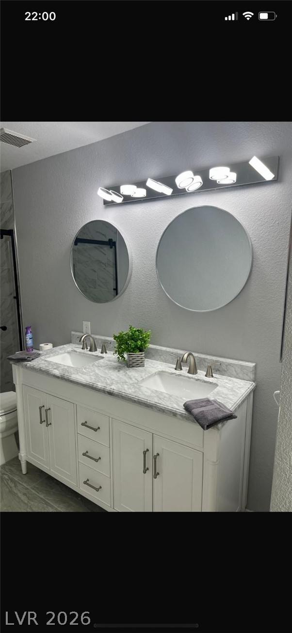 5131 South Lindell Road, Unit 205 Las Vegas, NV 89118 - Photo 15 of 22 Full bath featuring double vanity, walk in shower, a sink, and toilet