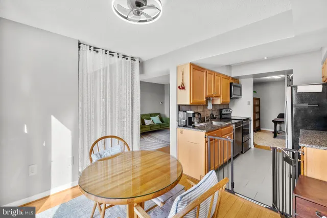 a kitchen with stainless steel appliances granite countertop a stove a sink dishwasher and a refrigerator with wooden floor