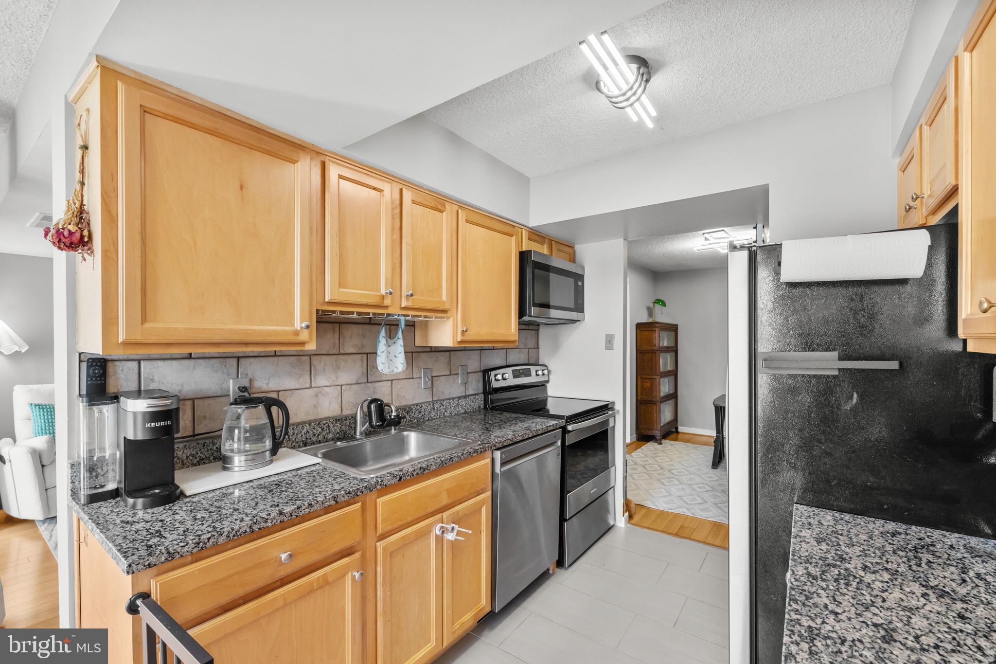 4500 South Four Mile Run Drive, Unit 222 Arlington, VA 22204 - Photo 12 of 41 a kitchen with stainless steel appliances granite countertop a refrigerator and a sink