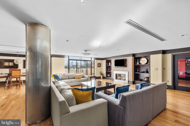 a living room with furniture a flat screen tv and a large window