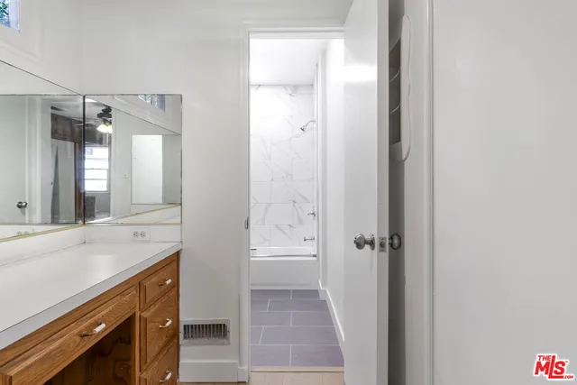 a bathroom with a granite countertop sink mirror and a shower