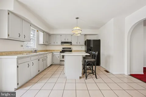a kitchen with cabinets and chairs