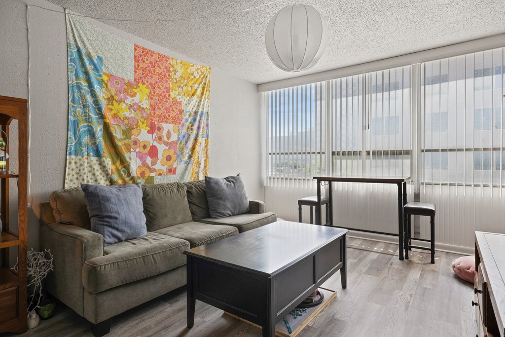 1800 Lavaca Street, Unit 207 Austin, TX 78701 - Photo 12 of 24 Living room featuring a textured ceiling and wood finished floors