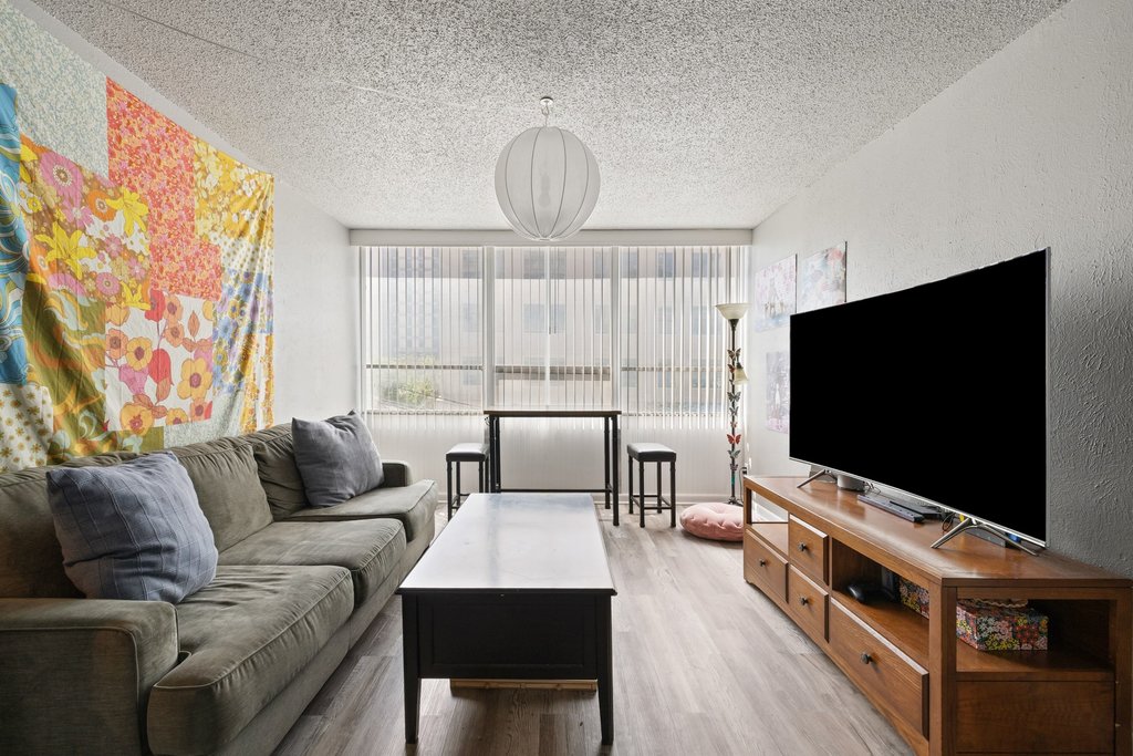 1800 Lavaca Street, Unit 207 Austin, TX 78701 - Photo 16 of 24 Living area featuring a textured ceiling and light wood-style floors