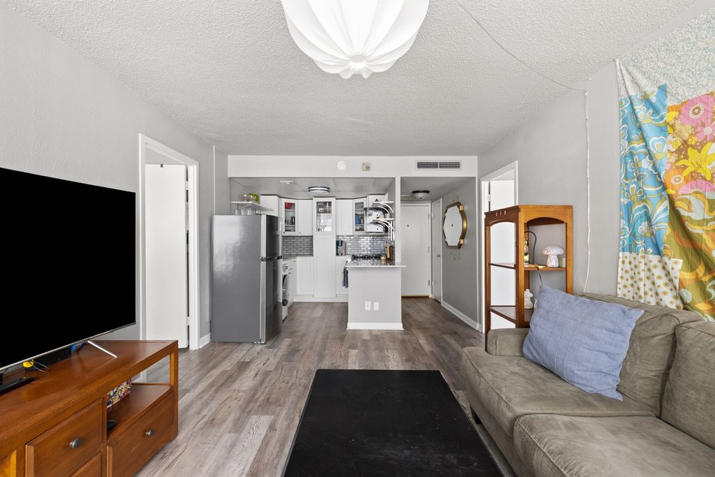 1800 Lavaca Street, Unit 207 Austin, TX 78701 - Photo 18 of 24 Living area with light wood finished floors and a textured ceiling