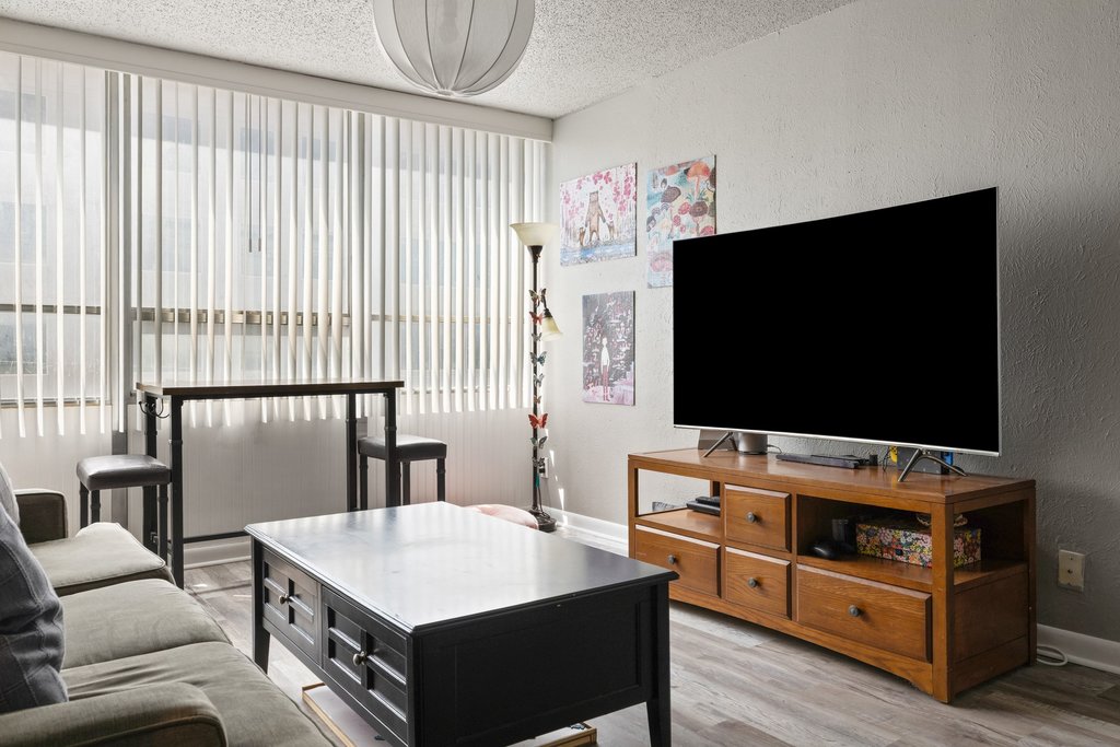 1800 Lavaca Street, Unit 207 Austin, TX 78701 - Photo 20 of 24 Living area with a textured ceiling, light wood-type flooring, and a textured wall