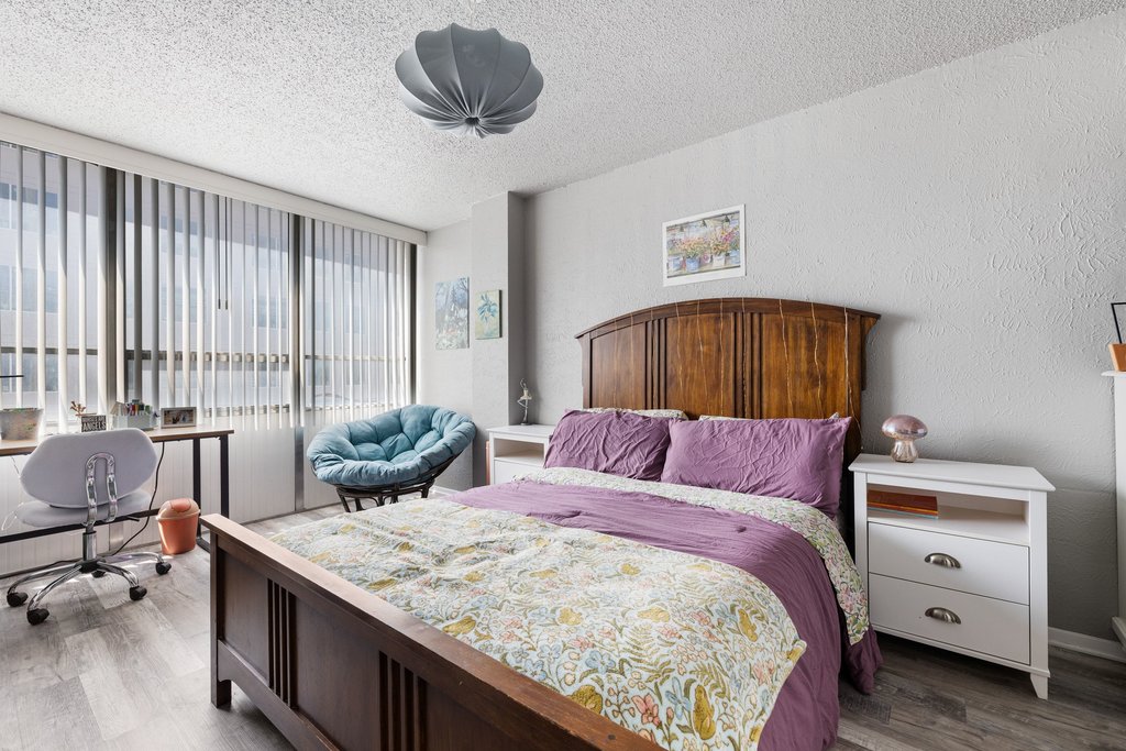 1800 Lavaca Street, Unit 207 Austin, TX 78701 - Photo 4 of 24 Bedroom featuring wood finished floors, a textured ceiling, and expansive windows