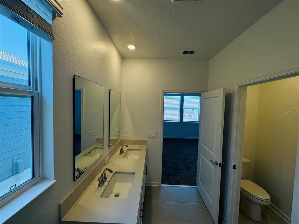 1952 Rider Rain Lane Apopka, FL 32703 - Photo 20 of 34 a bathroom with a sink mirror toilet and shower