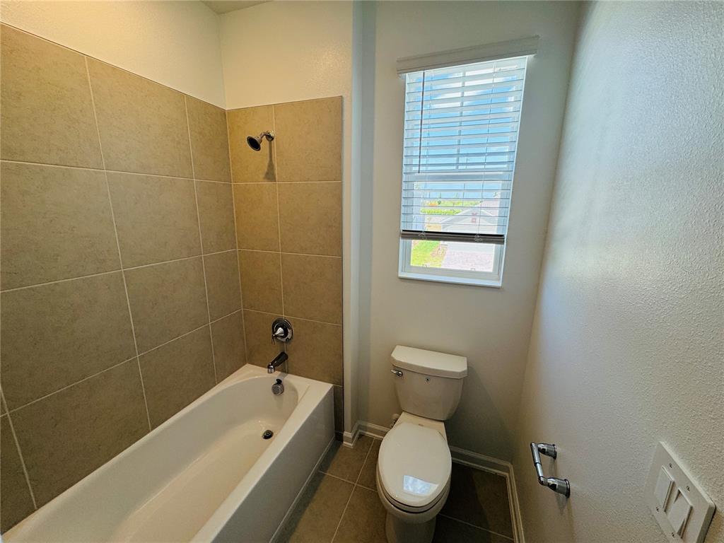 1952 Rider Rain Lane Apopka, FL 32703 - Photo 27 of 34 a white toilet sitting next to a bath tub and shower