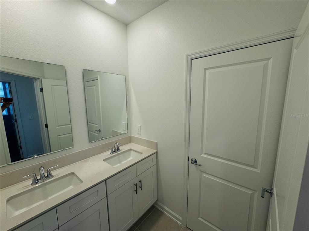 1952 Rider Rain Lane Apopka, FL 32703 - Photo 28 of 34 a bathroom with 2 sink and a mirror