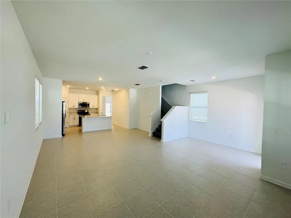 a view of a livingroom with furniture and a kitchen view