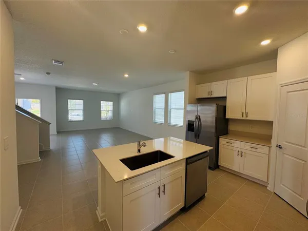 a kitchen that has a sink a stove top oven and refrigerator