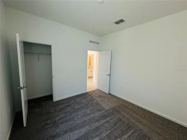 an empty room with wooden floor and closet