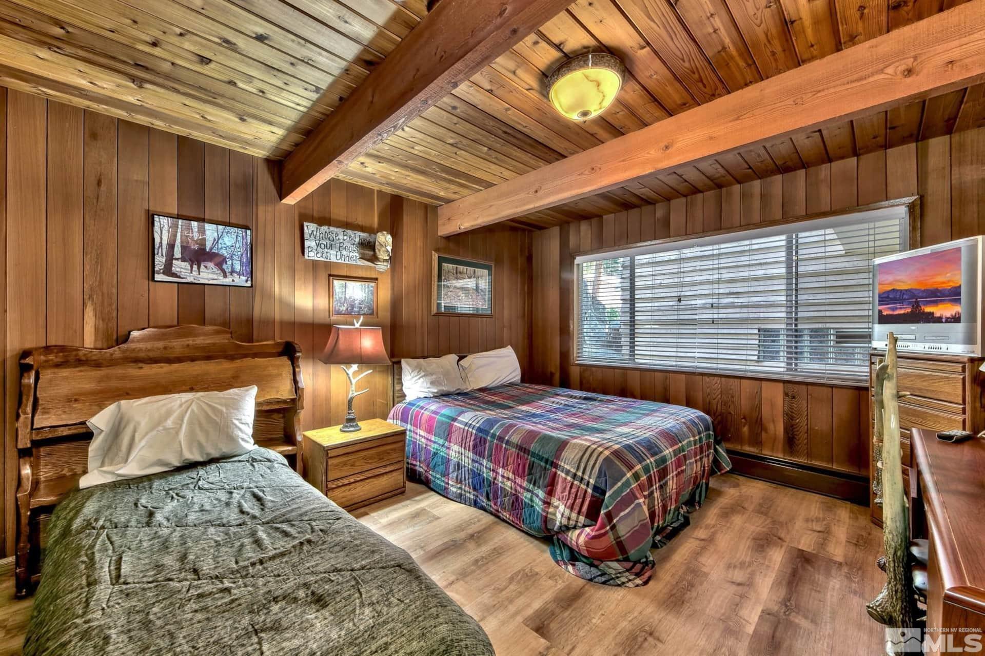 173 Juniper Drive Stateline, NV 89449 - Photo 15 of 29 a bedroom with a bed a dresser next to a window