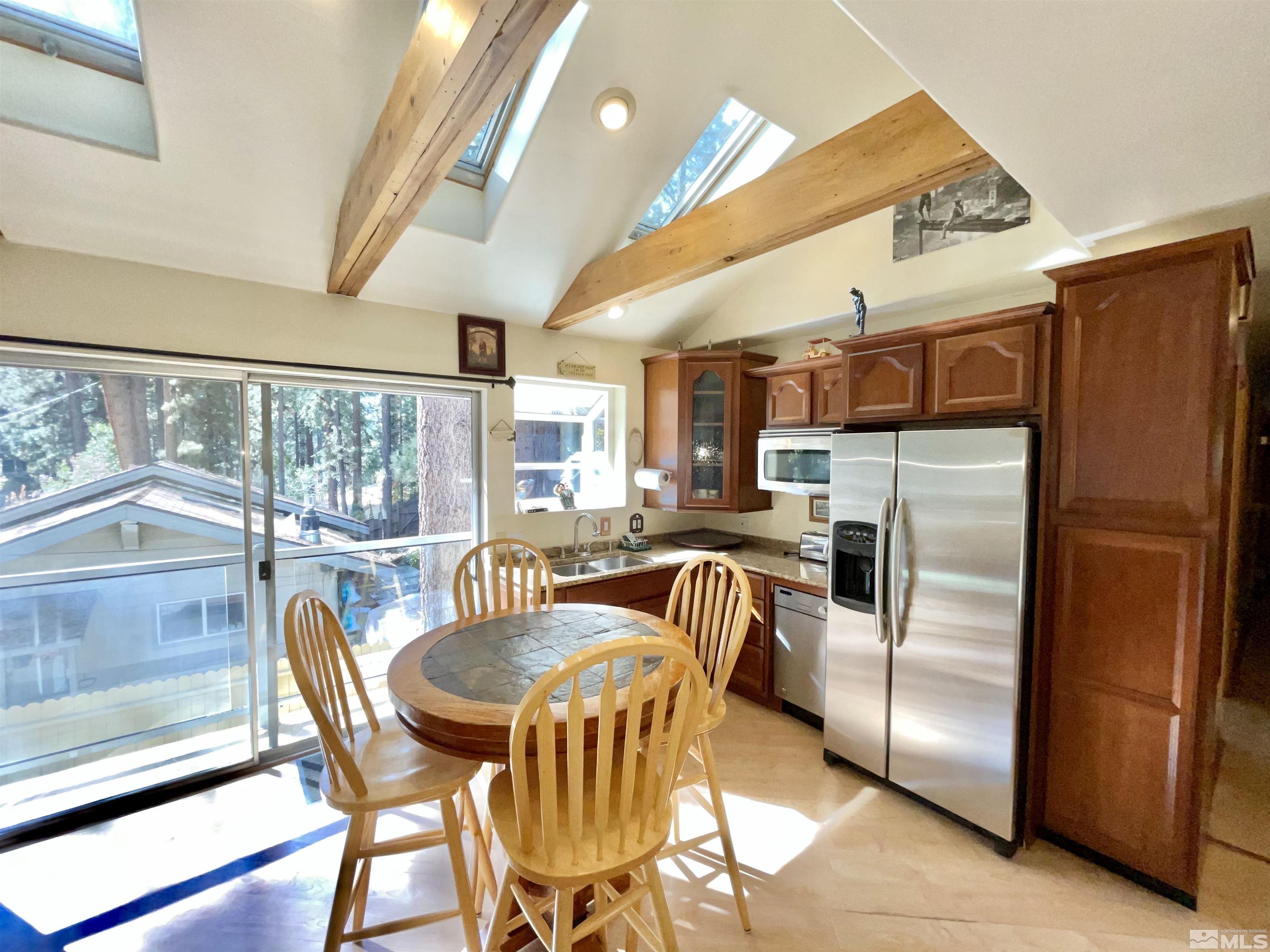 173 Juniper Drive Stateline, NV 89449 - Photo 9 of 29 a kitchen with stainless steel appliances granite countertop a table chairs and a refrigerator