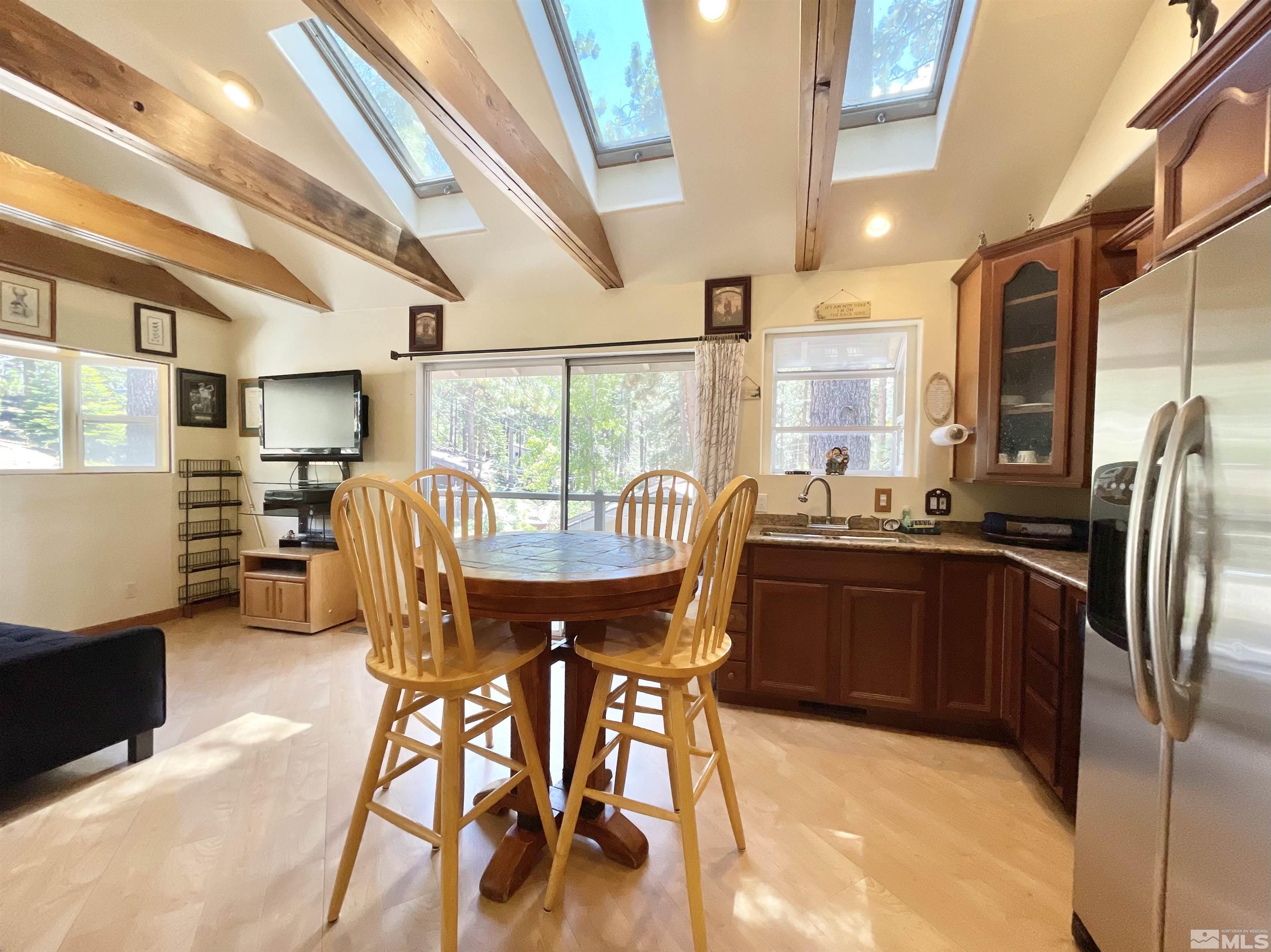 173 Juniper Drive Stateline, NV 89449 - Photo 10 of 29 a kitchen with stainless steel appliances granite countertop a stove a refrigerator a sink a dining table and chairs with wooden floor
