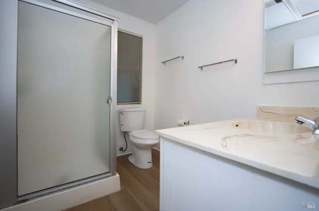 a bathroom with a sink a toilet and shower