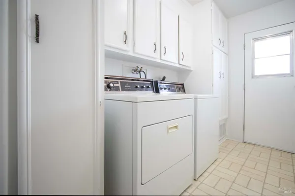 a kitchen with white cabinets and white appliances