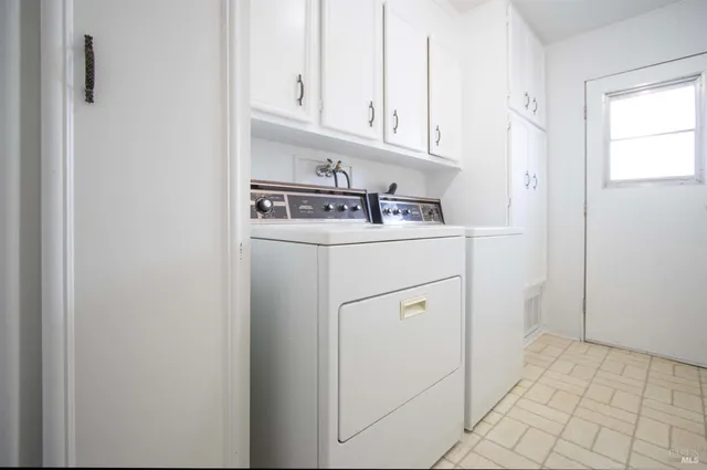 a kitchen with white cabinets and white appliances