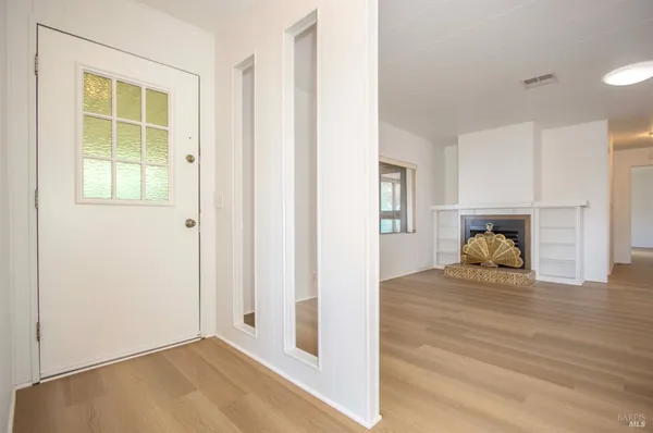 a view of empty room with window and wooden floor