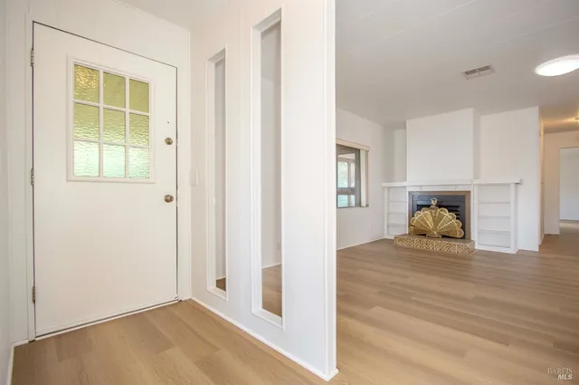 a view of empty room with window and wooden floor