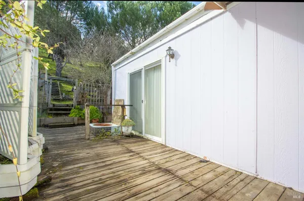 a view of backyard with wooden deck and seating space
