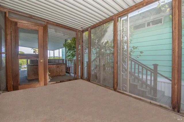 a view of a porch with a table and chairs