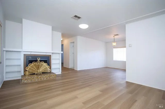 a room with wooden floor and a fireplace