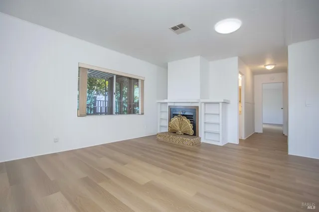 a view of a room with wooden floor and window