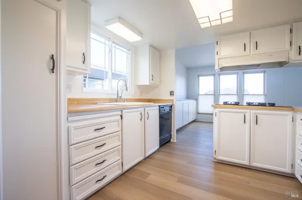 a kitchen with white cabinets and white appliances