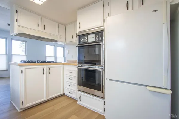 a kitchen with white cabinets and stainless steel appliances