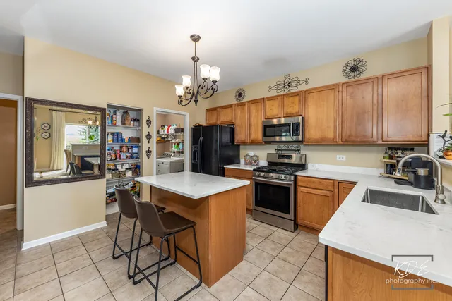 a kitchen that has a lot of cabinets in it and stainless steel appliances