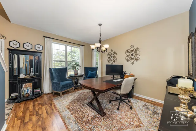 a dining room with furniture a chandelier and wooden floor