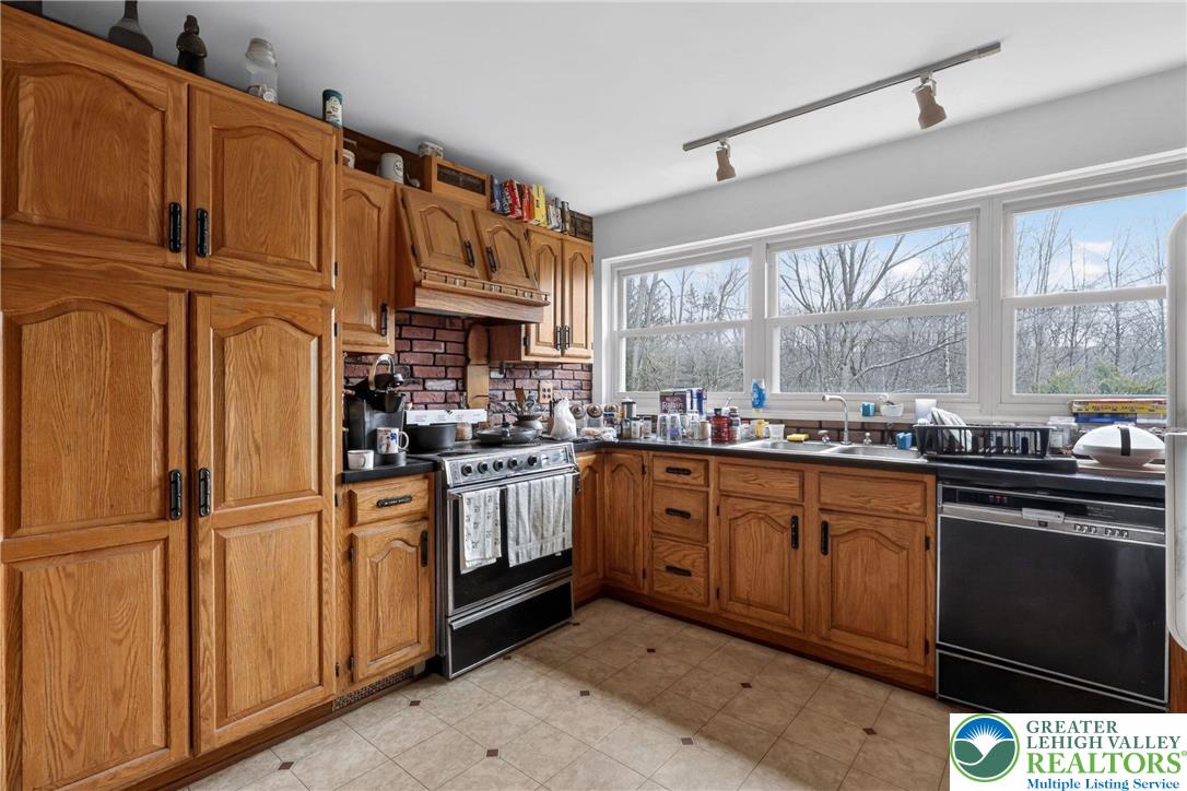 650 Chapman Lake Road Scott Township, PA 18433 - Photo 10 of 52 a kitchen with stainless steel appliances granite countertop a refrigerator a sink dishwasher a stove and white cabinets with wooden floor