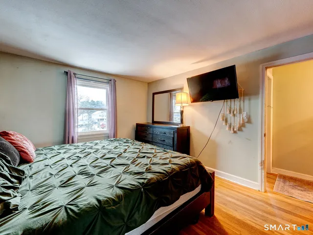 a bedroom with a bed and a flat screen tv