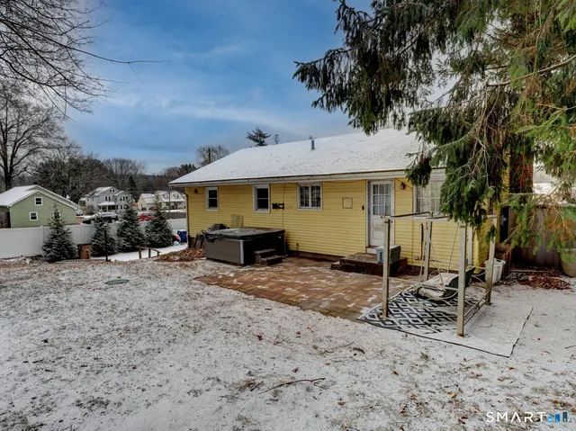 a view of a blue house with yard and sitting area