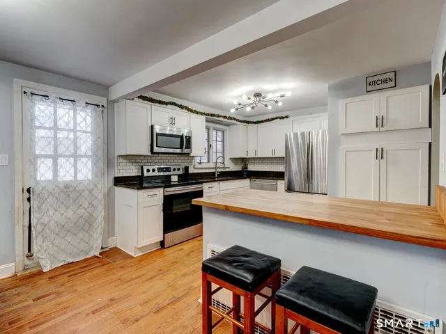 a kitchen with granite countertop stainless steel appliances and white cabinets