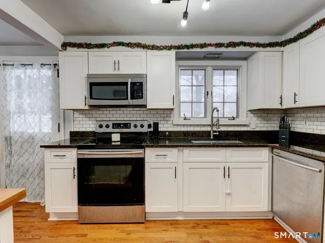 a kitchen with granite countertop a stove and a sink