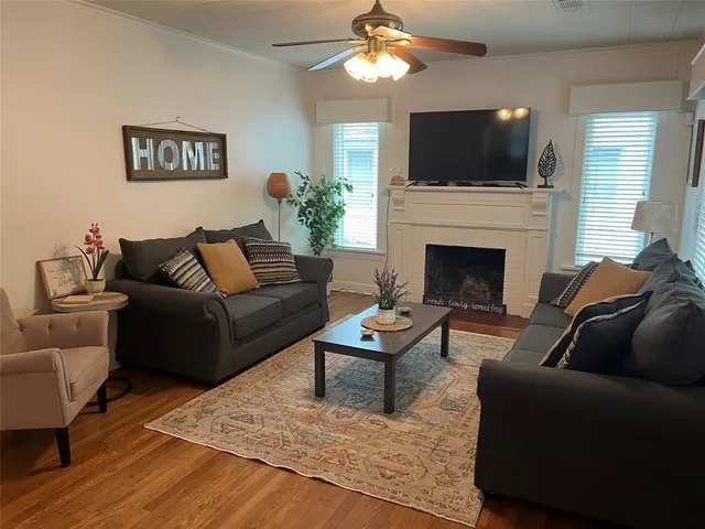 a living room with furniture a flat screen tv and a fireplace
