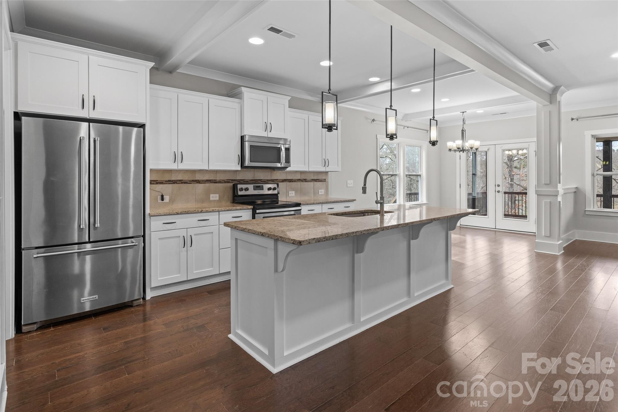 12039 Spinnaker Drive Tega Cay, SC 29708 - Photo 11 of 48 a kitchen with stainless steel appliances granite countertop a refrigerator a sink a stove and white cabinets
